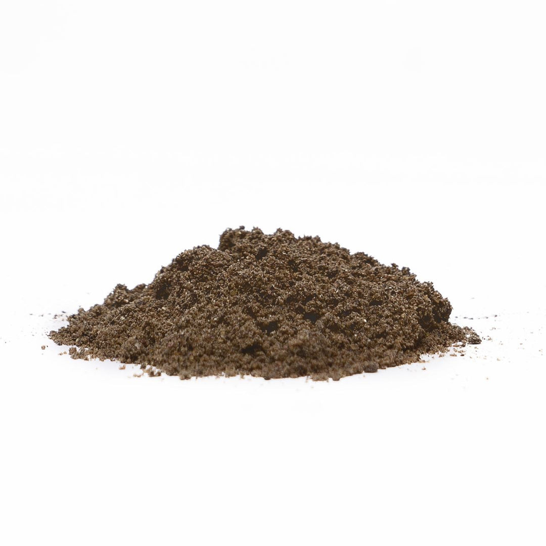 Auf diesem Bild sieht man den dunkelbraunen Blackdeere Bait Activator Fish Explosion, der auf einem Haufen auf dem Boden liegt. Dieser ist pulverförmig und ziemlich fein.