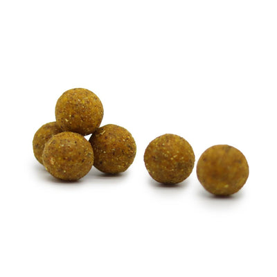 Auf diesem Bild sieht man die gelben Blackdeere Classic Corny Boilies, die einzelt verteilt auf dem Boden liegen.